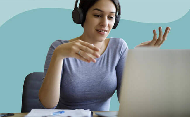 Picture of a happy woman having a video conference with her fertility doctor in Costa Rica.  The woman is smiling and looking into a laptop computer.